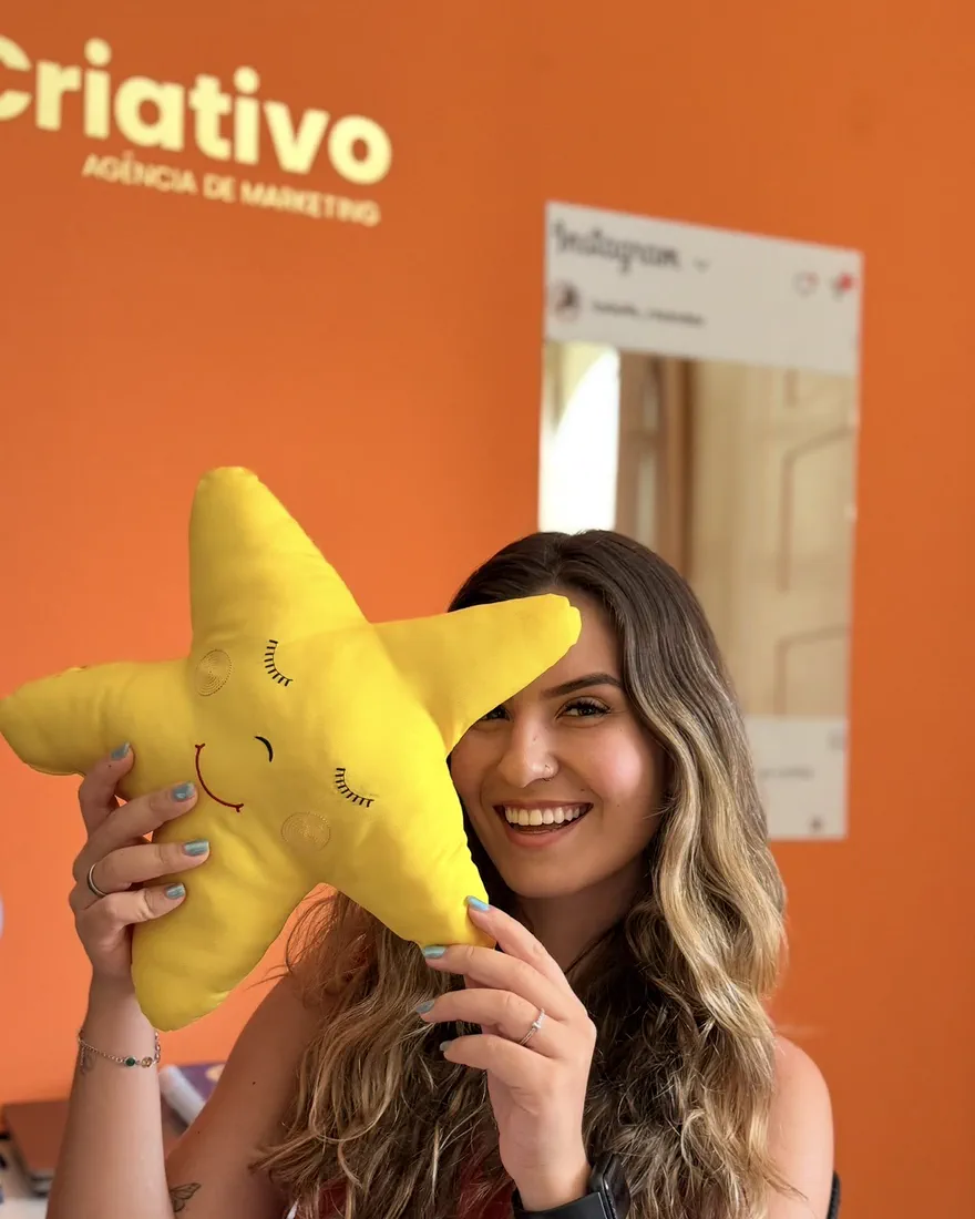 Izabelle Rezende, fundadora da Re.Criativo, segurando uma almofada de estrela