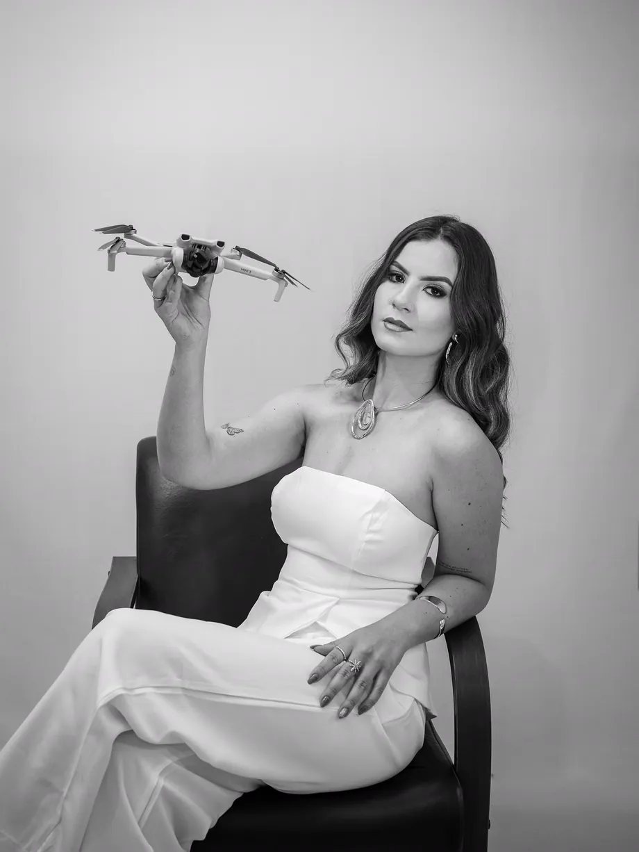 Foto em preto e branco da Izabelle Rezende segurando um drone